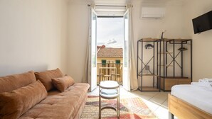 Et moderne soveværelse med sofa, seng, et lille bord og udsigt ud