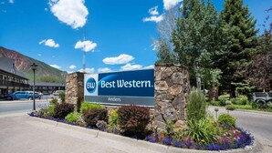 Segnaletica Best Western con un pilastro in pietra e aiuola fiorita.