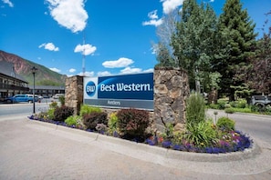 Best Western -kyltti, jossa on kivireunus ja kukkapenkit.