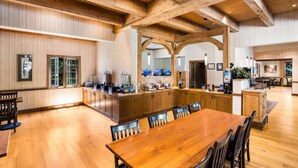 Un'ampia cucina con travi in legno, una grande isola e un'area pranzo con sedie.