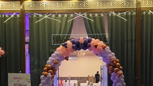 A checkered floor with a decorative arch made of balloons, a sign reading "Welcome to the Cheera 1st Birthday," and a chandelier in the background. - SHYAM RESORT (Khandwa)