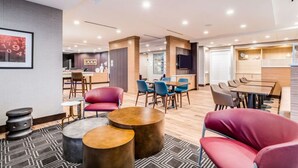 A modern hotel lobby with a bar area, seating arrangements, and a reception desk.