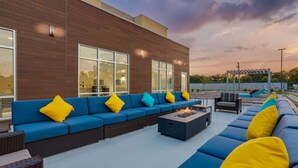 A modern outdoor seating area with blue and yellow cushions, a fire pit, and a pergola. - Casino Nearby | Free Breakfast + Full Kitchen (Waukegan)