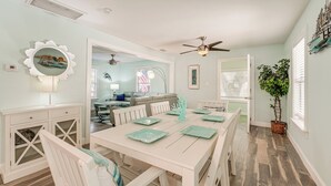 A dining area with a white table set for six, a ceiling fan, and a view into the living room. - 6 Mi to Raymond James Stadium: Tampa Retreat! (Tampa)