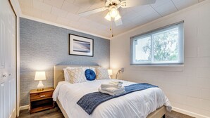 A bedroom with a bed, nightstands, a ceiling fan, a window, and a wall-mounted picture. - Florida Adventure Hub Near Top Attractions & Lakes (St. Cloud)