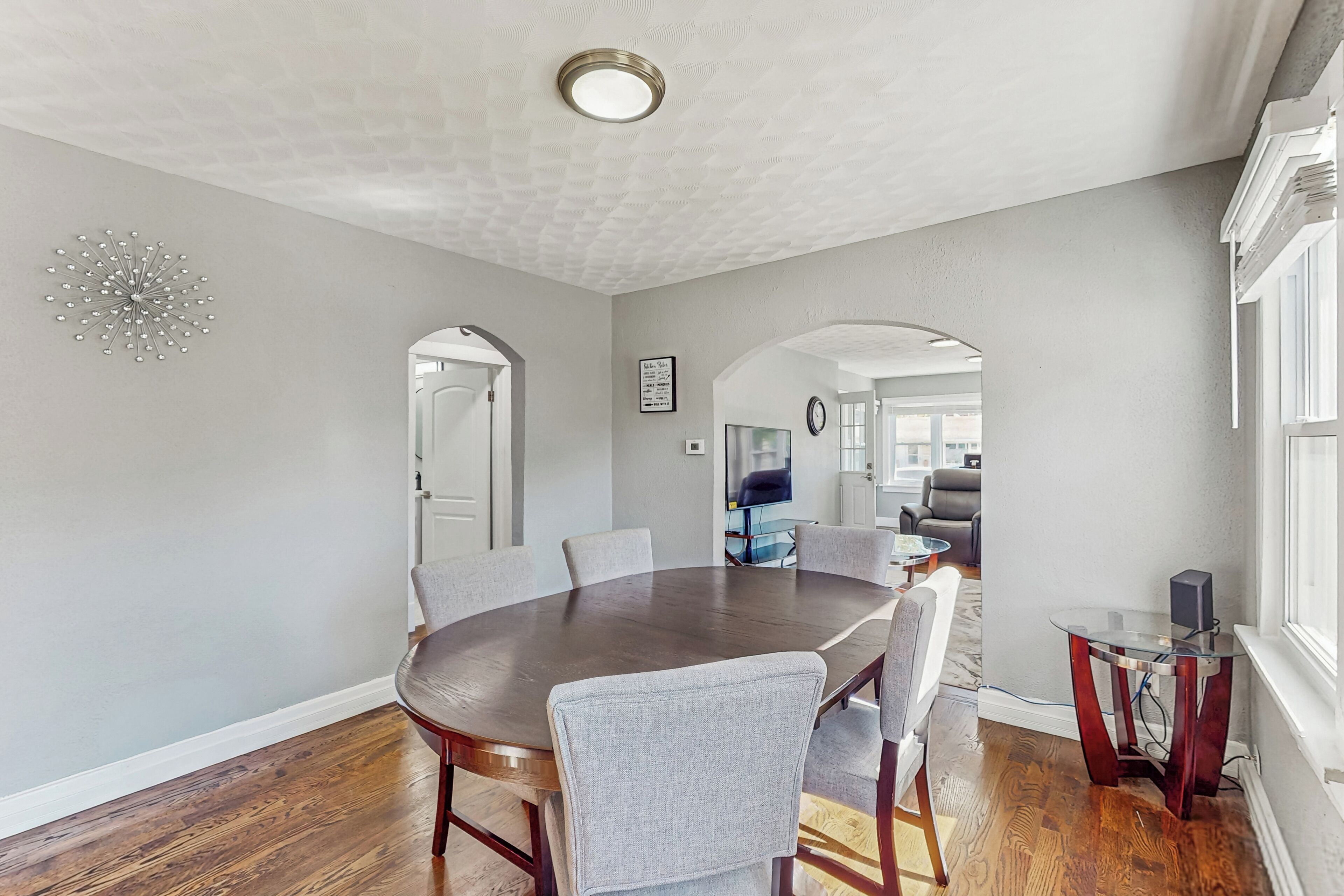 A dining area with a round table, chairs, and a small side table.
