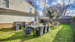 A backyard with a patio table and chairs, a wooden fence, and a house in the background. - Explore & Relax! Norfolk Duplex < 1 Mi to Beach (Norfolk)