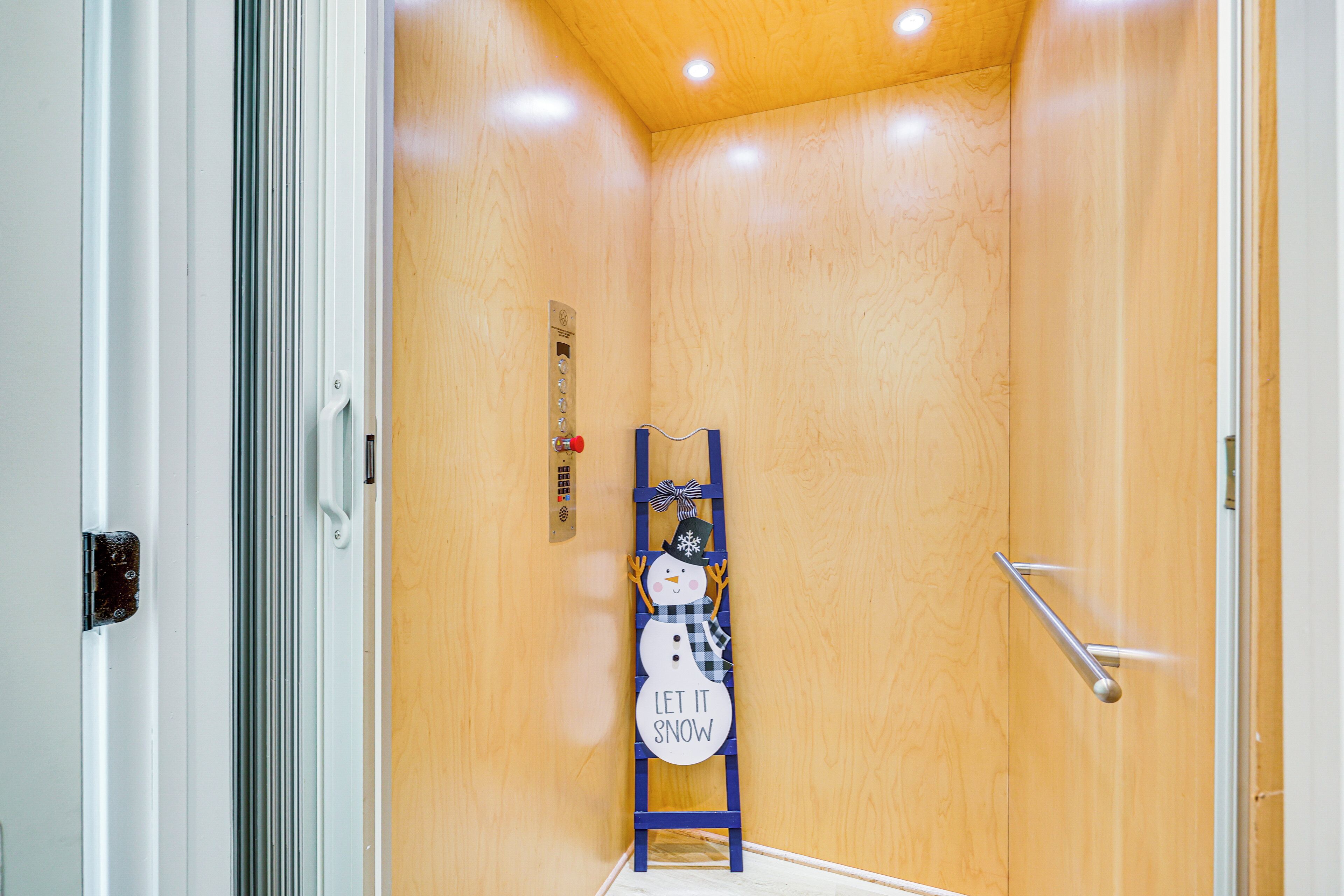 Una habitación con paneles de madera, una escalera de madera y una decoración con un muñeco de nieve.