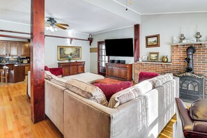 A cozy living room with a sofa, a television, a fireplace, and wooden flooring. - 4 Mi to Camelback! Group-friendly Poconos Cabin (Tannersville)
