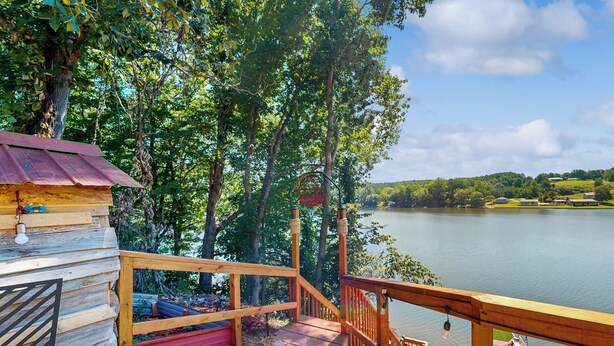 Una cabana de fusta amb terrassa i vista a un llac.