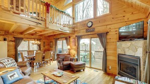 Une cabine spacieuse dotée d’un grand salon, d’une cheminée, d’un coin repas et d’un balcon offrant une vue sur l’extérieur.