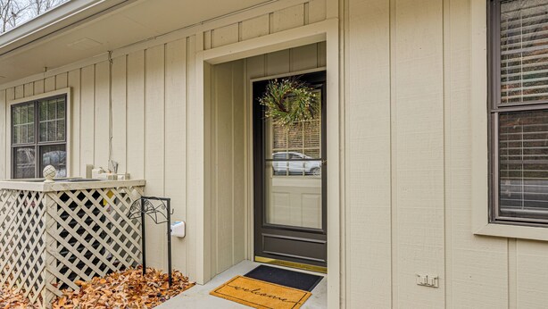 A house with a front door, a welcome mat, a lattice fence, and a window with blinds. - Franklin Golf Condo: '13th Hole Retreat'! (Franklin)