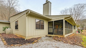 A single-story house with a covered porch, a chimney, and a gravel driveway.