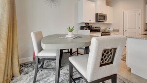 A modern kitchen with white cabinets, a microwave, and a dining area with a round table and two chairs. - Florida Snowbird Haven w/ Pool! Easy I-75 Access (Parrish)