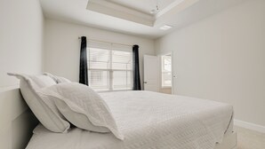 A bedroom with a bed, a window with curtains, a door, and a ceiling light. - Florida Snowbird Haven w/ Pool! Easy I-75 Access (Parrish)
