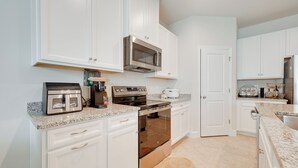 A modern kitchen with white cabinets, stainless steel appliances, and granite countertops. - Florida Snowbird Haven w/ Pool! Easy I-75 Access (Parrish)