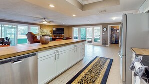 A spacious kitchen with a large island, white cabinetry, stainless steel appliances, and a ceiling fan. - 7 Mi to Paynes Prairie Preserve! Rural Retreat (Micanopy)