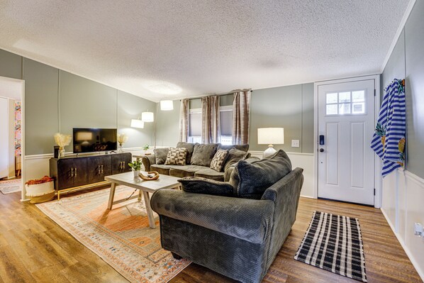 A living room with a grey sofa, a coffee table, a TV, and a patterned rug. - Port Austin Home Near Lake Huron w/ Fire Pit! (Port Austin)