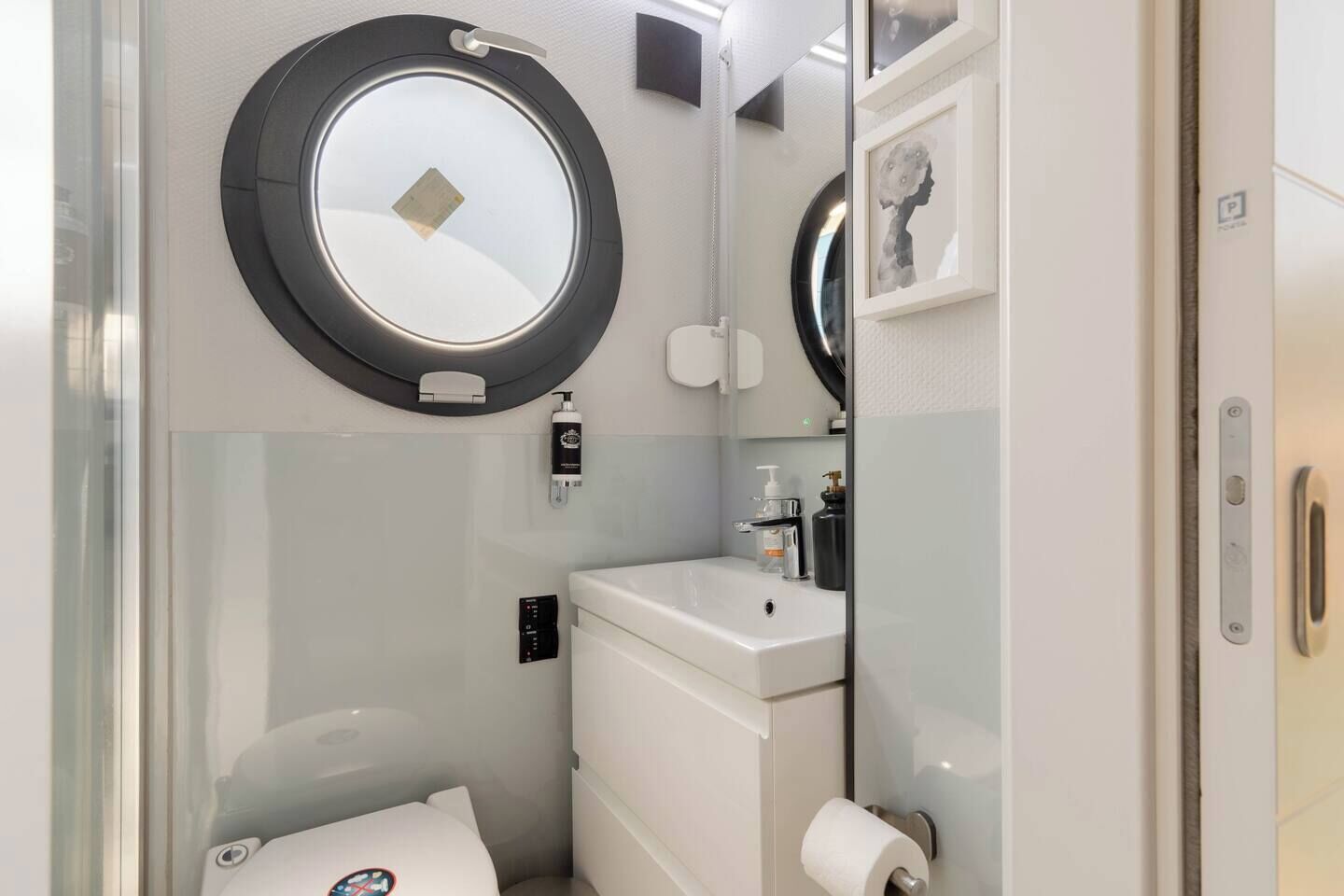 A compact bathroom with a toilet, sink, and a mirror.