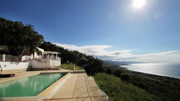 Una piscina con vista al mar y a las montañas.
