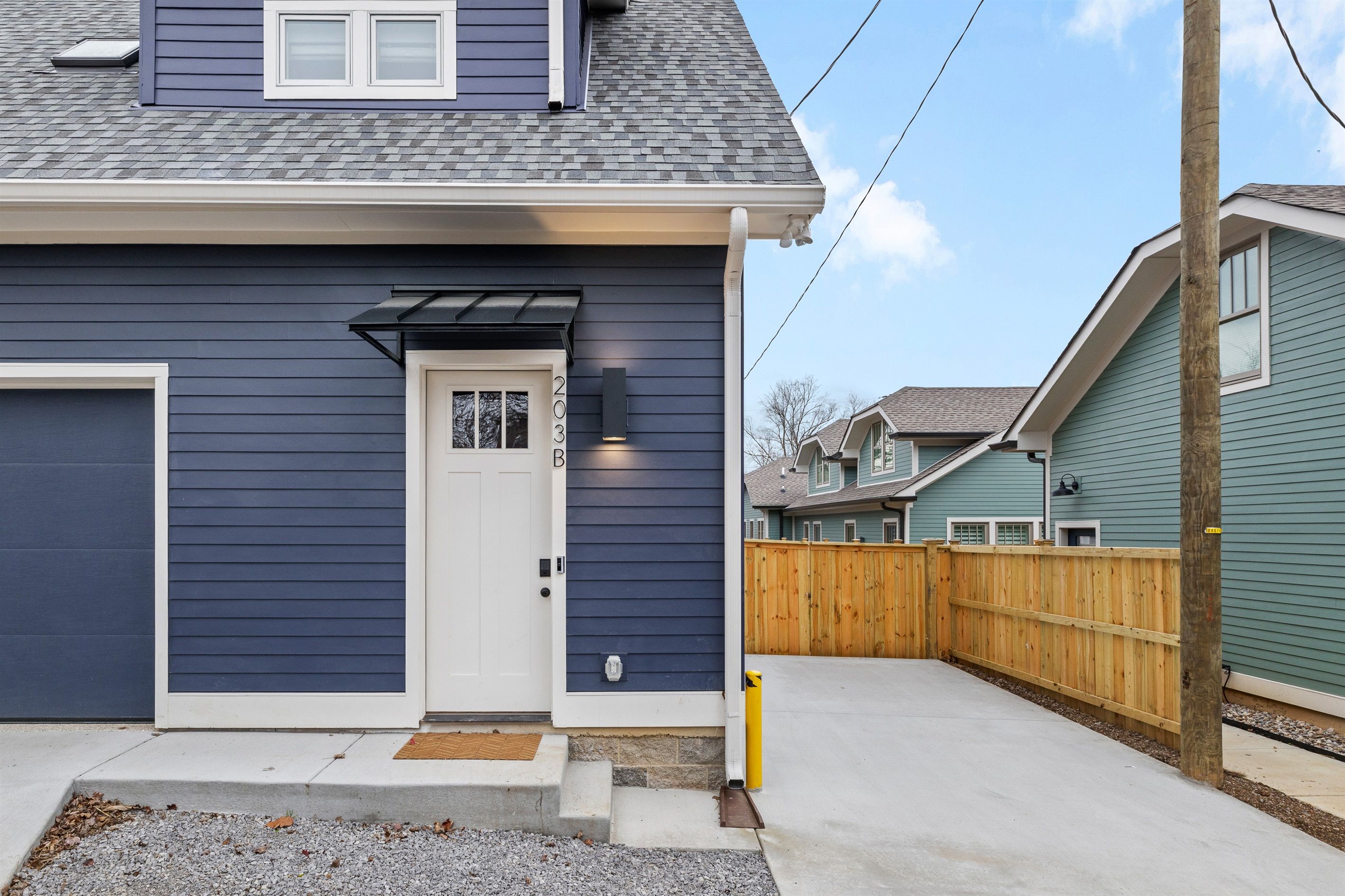 A residential house with a dark blue exterior, a white front door, and a small porch area.