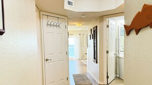 A hallway with wooden flooring, white walls, and a door with a coat rack. - Top Floor Beachfront - Great Views From Top Floor! Beach Service! (Fort Walton Beach)