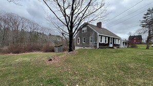 A two-story house with a large front yard, a small shed, and a tree. - Amazing 3-bedroom home, Full Kitchen, in Newcastle perfect for your getaway (Newcastle)