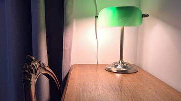 Una lámpara sobre una mesa de madera junto a una cortina.