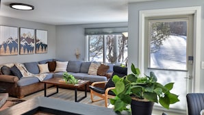 A modern living room with a sectional sofa, a coffee table, and a potted plant. - Fall Line Condo B7 1 Bedroom Home (Killington)