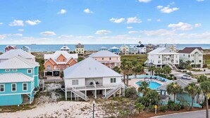 A coastal residential area with houses, a swimming pool, and a view of the ocean. - Indies 401 | 3BR/3BA Corner Condo | Sleeps 6 | Wraparound Balcony & Views (Gulf Shores)