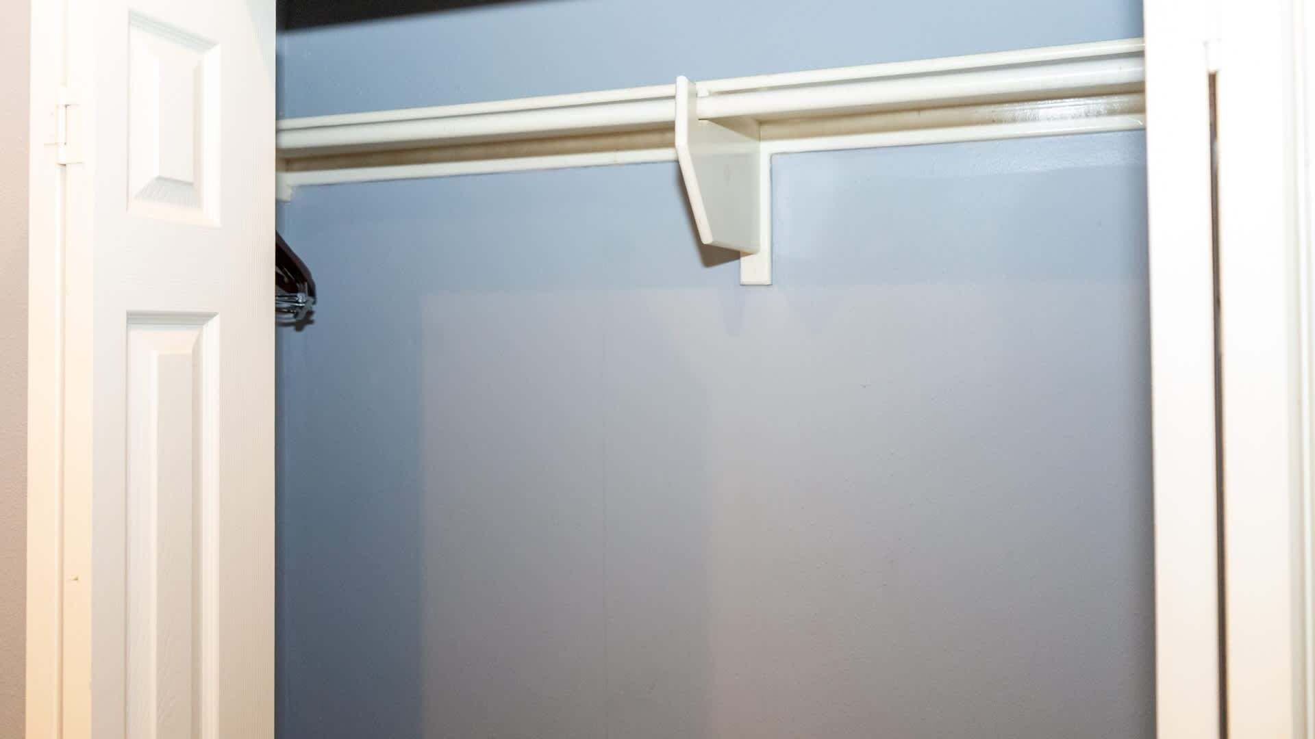 A closet with a white door and a light blue wall.