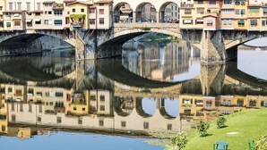 A stone bridge over a calm river with buildings on either side. - Wohnung 'San Firenze' mit Waschmaschine by Interhome (Florence)
