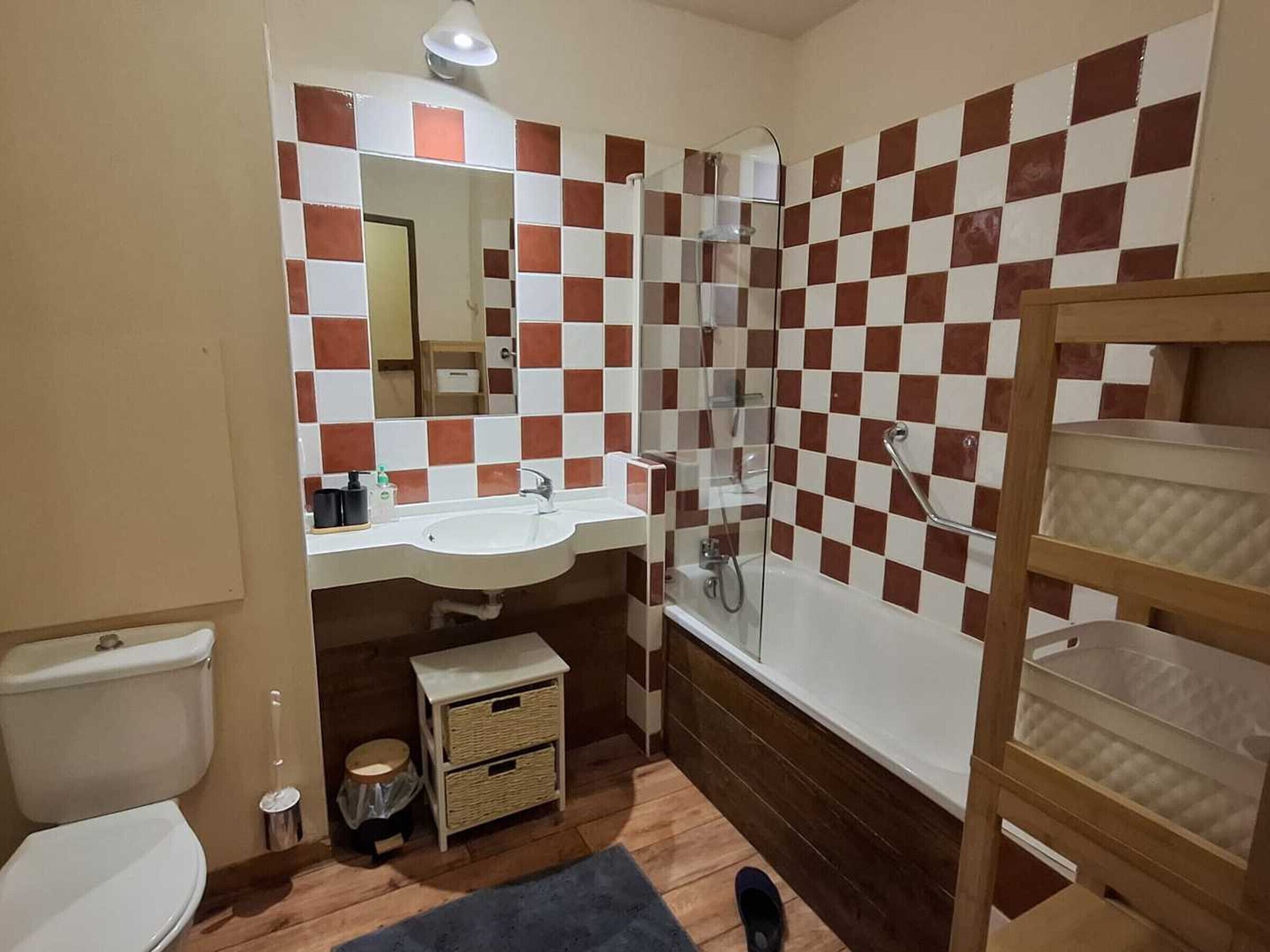 Une salle de bain équipée de toilettes, d’un lavabo, d’une douche et d’un miroir.