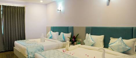 A hotel room with two beds, a ceiling fan, and a large window with curtains.