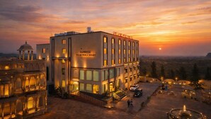 Een modern hotel met een bord waarop staat 'Sunrise Dream World Resort' bij zonsondergang.