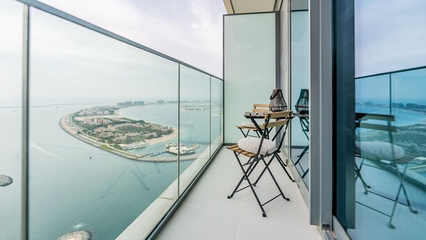 A high-rise balcony with a clear view of a coastal cityscape, including a marina and buildings. - Prime Waterfront Location with Stunning Palm Jumeirah Views, Close to Dubai’s Top Attractions (Dubai)