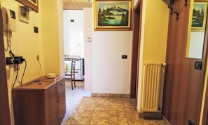 Ein Korridor mit einem Holzschrank, einem Heizkörper und einem Bild an der Wand.