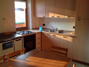 Geladeira, fogão, talheres/pratos/utensílios de cozinha