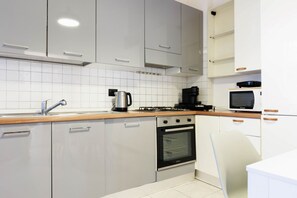 A modern kitchen with grey cabinets, a stainless steel oven, a coffee maker, and a microwave. - Orsini Sweet Home - Florence  (Florence)