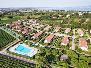 A residential area with a large swimming pool, surrounded by houses and greenery. - FeWo C-199 by Interhome (Lazise)