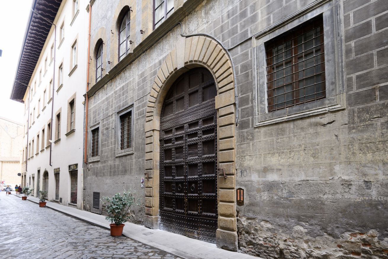 A historic building with a large arched door and multiple windows.