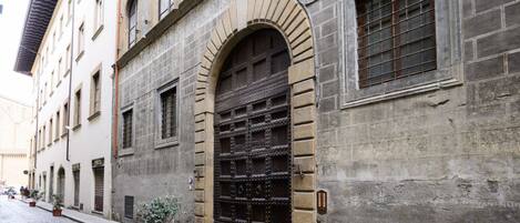 A historic building with a large arched door and multiple windows.