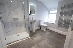 A bathroom with a glass-enclosed shower, a pedestal sink, a toilet, and a towel rack. - The Nook | Cotswolds Home | HOT TUB | Sleeps 9 (Eastington)