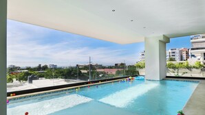 Ein Hallenbad mit freiem Blick auf die Stadt durch die Fenster.