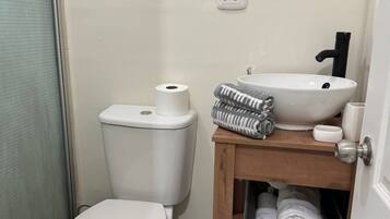 A small bathroom with a toilet, a sink, and a mirror.