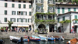 A hotel with a balcony, a gelateria, and several boats docked at the waterfront. - "Casa Rita AP. 1 - Gardasee". by Interhome (Limone sul Garda)