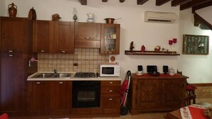 Een koelkast, een magnetron, een oven, kookgerei, borden en bestek