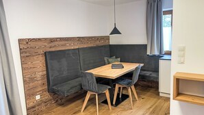 Ein modernes Zimmer mit einem Holzesstisch, einer Bank und einer Pendelleuchte.