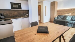 Eine moderne Küche mit Mikrowelle, Kaffeemaschine und einem Holztisch mit einem Buch.