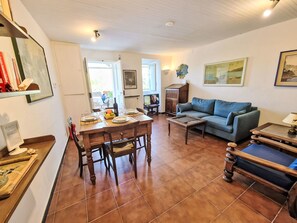 A living room with a dining table, sofa, and a TV. - Ein Garten auf Camogli von Holiday World by Interhome (Camogli)